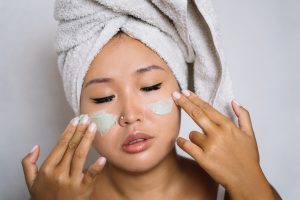 A Woman Applying a Cosmetic Product on her Face