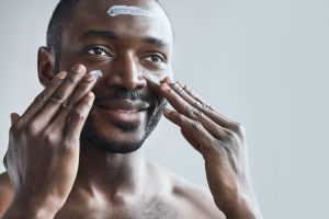 Man Putting on Cream on His Face