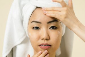 Woman putting cosmetic product on her face